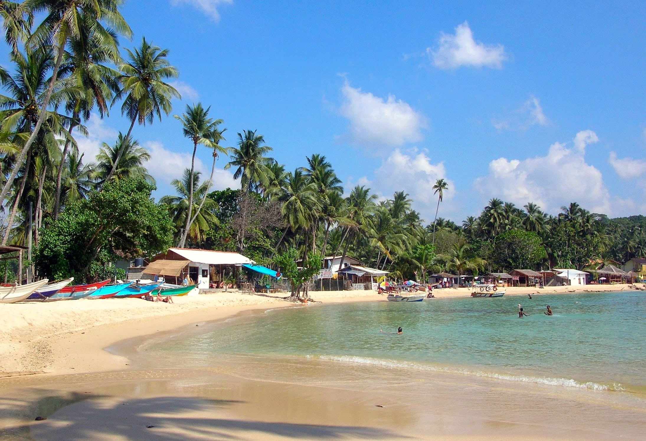 Palm-lined beach and calm bay at Unawatuna