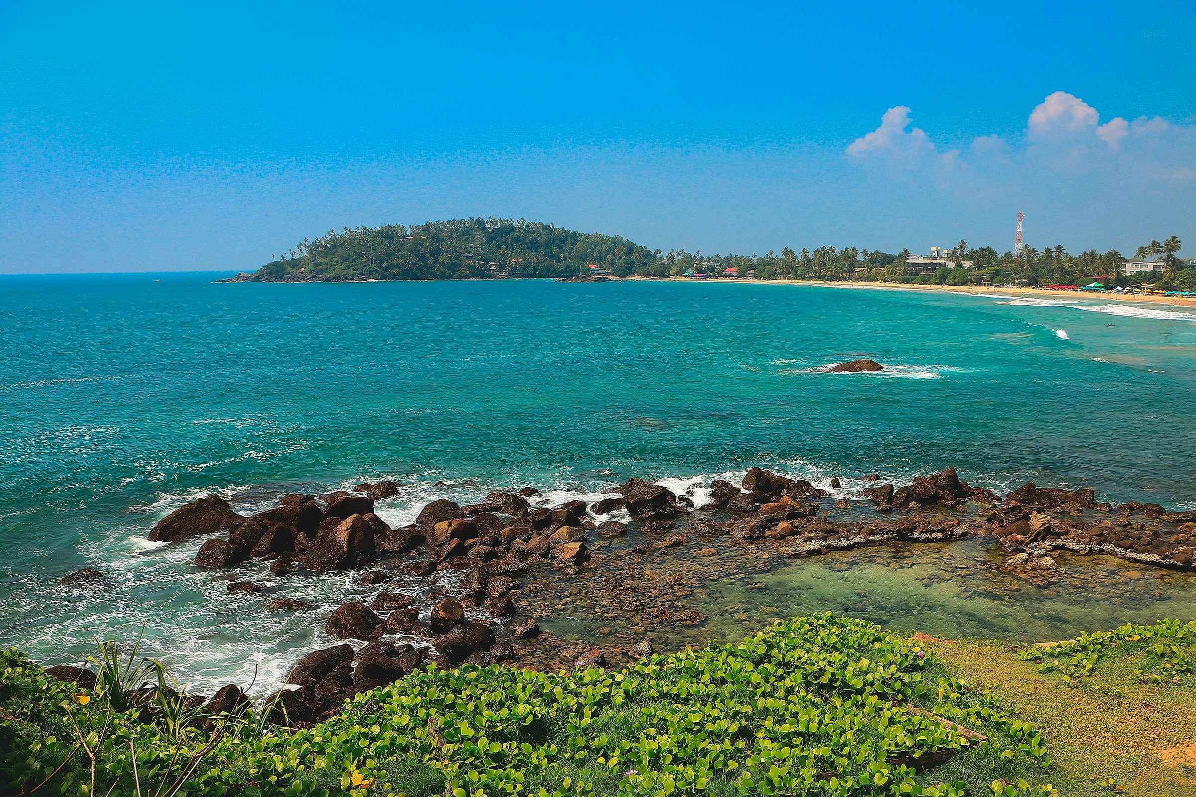 Turquoise water and rocks along the bay at Mirissa
